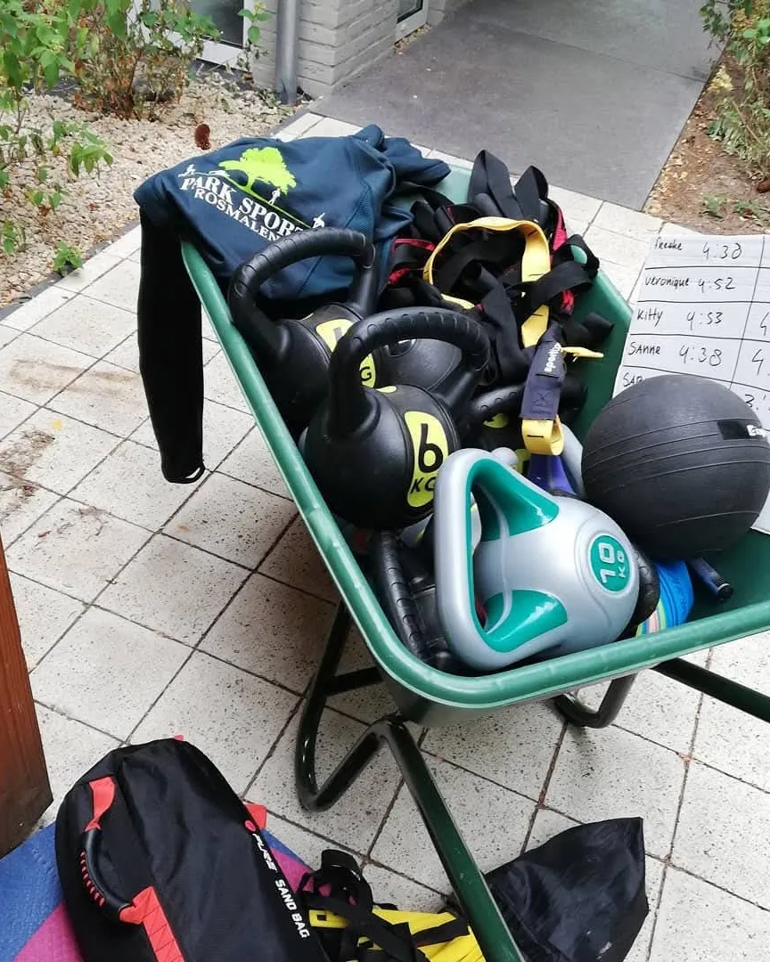 Een kruiwagen vol trainingsmateriaal: kettlebells, ballen en weerstandsbanden
