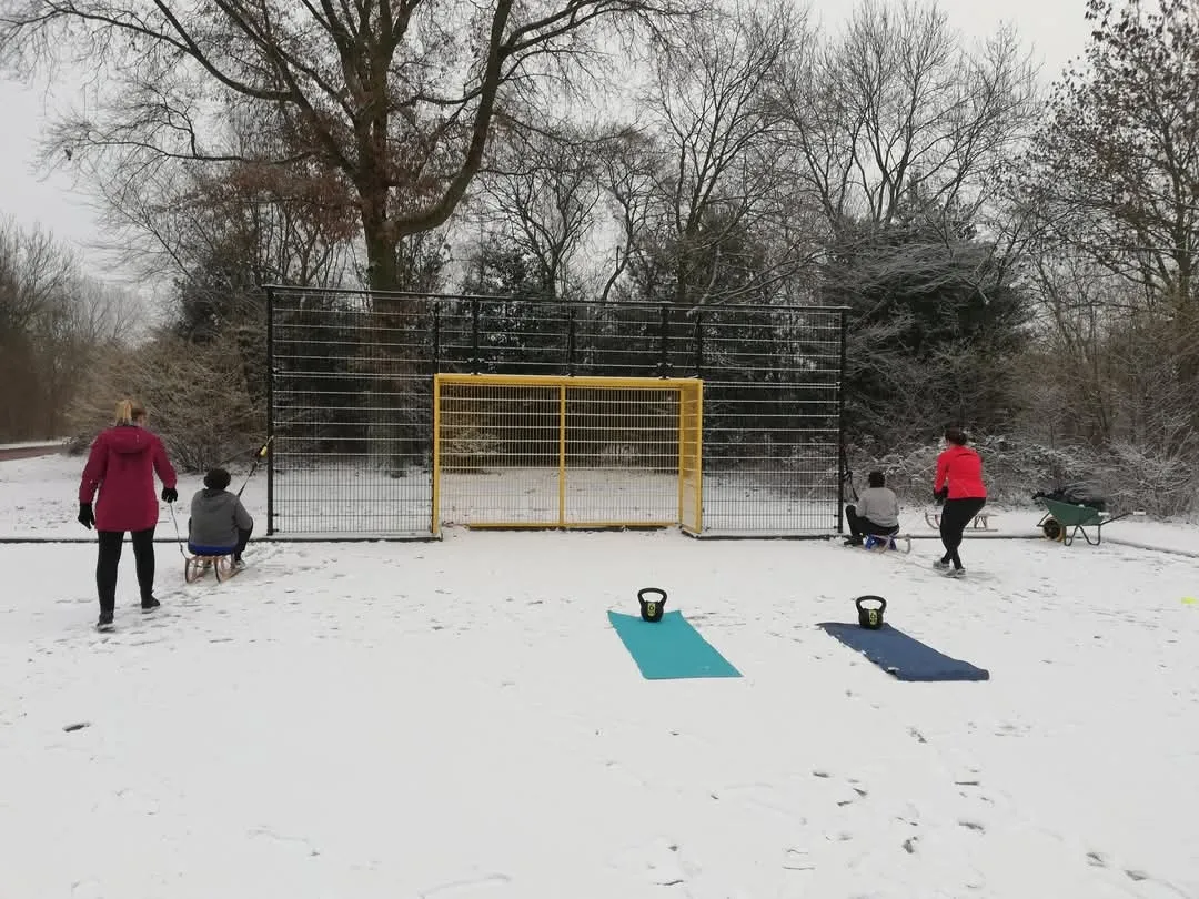 Een buitentraining in de sneeuw, met matten en kettlebells